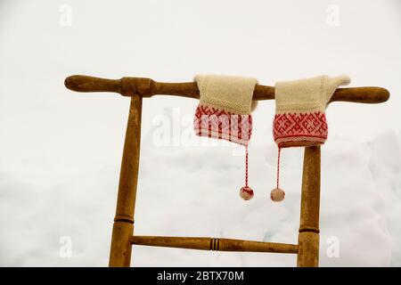 Ein Paar handgestrickte Fäustlinge, die am Griff eines Kicks hängen, Boda kyrkby, Rättvik, Dalarna, Dalecarlia, Schweden Stockfoto