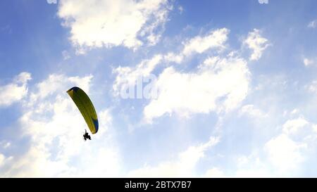 Paragleiter fliegt gegen den Himmel über dem Khao Jeen Lae Berg in Lopburi, Thailand Stockfoto