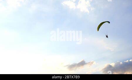 Paragleiter fliegt gegen den Himmel über dem Khao Jeen Lae Berg in Lopburi, Thailand Stockfoto