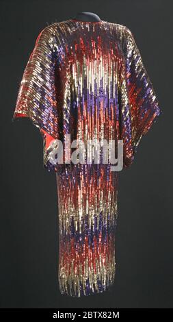 Kleid getragen von Celia Cruz. Rot, Gold und blau Paillettenkleid mit horizontalen, abwechslungsreichen Streifen und großen offenen Ärmeln. Stockfoto