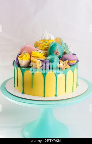 Geburtstag gelbe Kuchen mit grün geschmolzene Schokolade, Cake Pops, Cupcake, Schokolade und Donut. Kopierbereich. Stockfoto