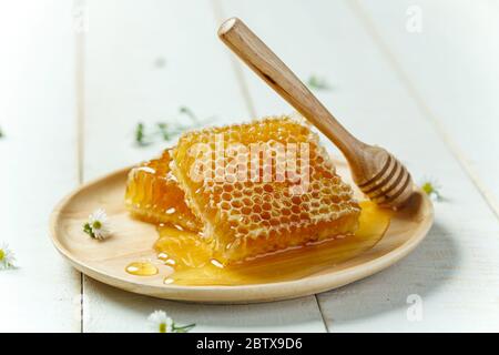 Waben mit Dipper auf weißem Holzhintergrund Stockfoto