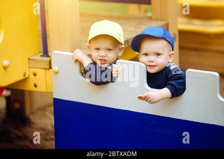 2 Zwillingsbrüder spielen zusammen auf dem Spielplatz, 1-2 Jahre alt Stockfoto