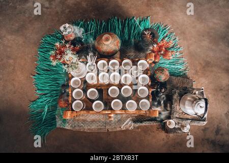 Mit Tassen äthiopischen Kaffee serviert mit aromatischer Essenz. Weihrauch und Myrrhe, die durch eine heiße Kohle entzündet werden, um Rauch zu erzeugen, der irgendeinen wegträgt Stockfoto