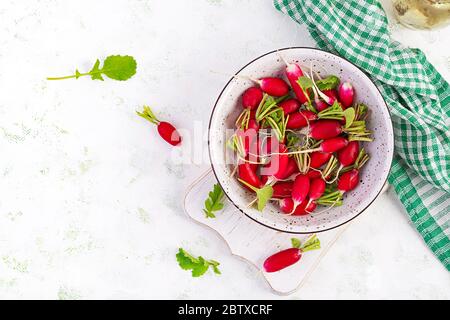 Frische rosa Radieschen in Schale auf hellem Hintergrund. Draufsicht, flaches Layout, Kopierbereich. Stockfoto