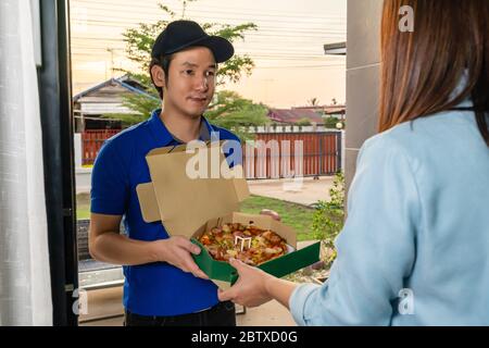 Lieferung Mann liefert Pizza Essen an die Kundin Frau zu Hause Stockfoto