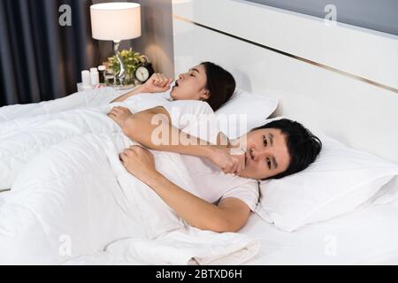 Kranke Paar hustet und leidet an Viruserkrankungen und Fieber auf dem Bett zu Hause Stockfoto