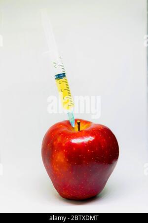 Apfel mit Spritzen. Genetisch Veränderter Organismus Stockfoto