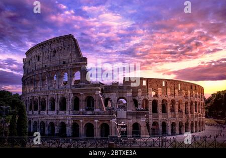 Kolosseum in Rom bei Sonnenuntergang gegen lila bewölkten Himmel, Italien Stockfoto