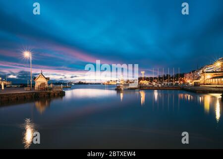Helsinki, Finnland. Landschaft Mit City Pier, Anlegestelle Bei Winter Sonnenaufgang Sonnenuntergang Zeit. Blauer Himmel Spiegelt Sich In Der Ruhigen Meeresoberfläche Wider. Liegeplatz In Beleuchtung Stockfoto