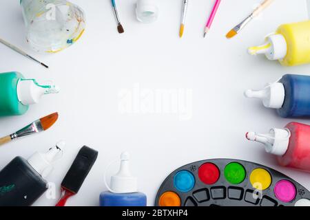 Bunte Palette von Acrylfarbe und Pinsel auf weißem Hintergrund im Künstlerstudio. Kreativität und Bildungskonzept. Niemand, Platz für Text Stockfoto