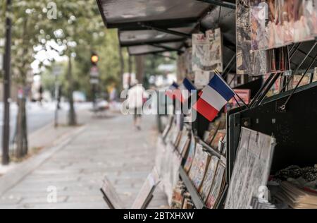 Ein Stall, der französische Flaggen und alte Comics verkauft, am linken Ufer der seine in Paris, Frankreich Stockfoto