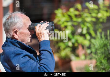 Älterer Mann mit Fernglas in der Ferne. Stockfoto