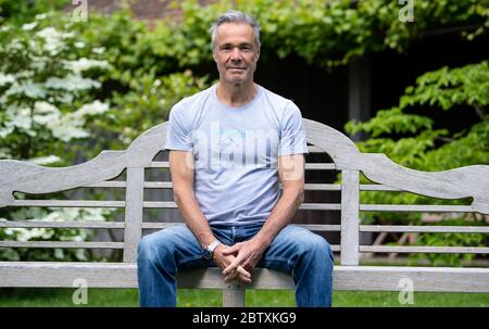 Utting, Deutschland. Mai 2020. EXKLUSIV - Hannes Jaenicke, Schauspieler, sitzt während eines Fotoshootings in seinem Garten. Jaenicke rät vom Lachsessen ab. Für eine ZDF-Dokumentation hat sich der Schauspieler mit dem Fisch beschäftigt. Der Film "Hannes Jaenicke: In Aktion für den Lachs" wird am 16. Juni um 10.15 Uhr im ZDF ausgestrahlt. Kredit: Sven Hoppe/dpa/Alamy Live News Stockfoto