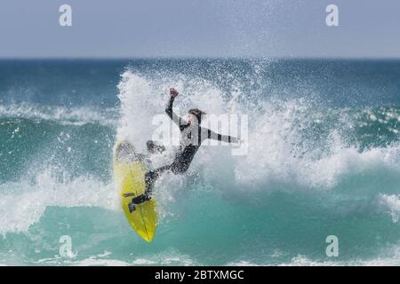 Spektakuläre surfen Aktion als Surfer reitet eine Welle an Fistral in Newquay in Cornwall. Stockfoto