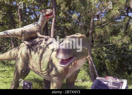 Busan, Südkorea, 14. September 2019: Skulpturen von Iguanodon und Angriff auf sie adazavr im Amnam Park Stockfoto