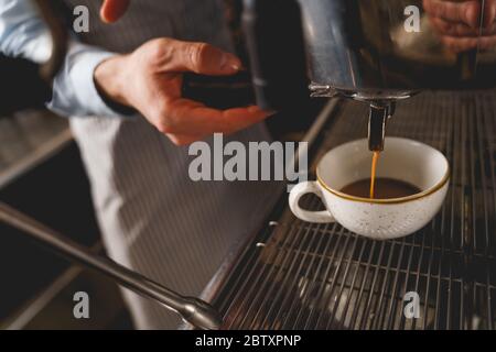 Barista mit professioneller Kaffeemaschine im Café Stockfoto