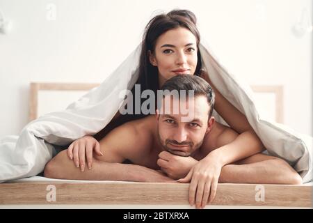 Dunkelhaarige Dame, die auf einem mans Rücken liegt Stockfoto