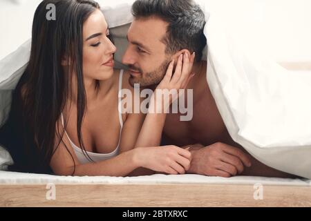 Zwei junge Ehepartner liegen unter der Decke Stockfoto