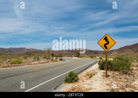 Ein Straßenschild auf einer Straße durch die Wüste im Joshua Tree National Park, Kalifornien, USA. Stockfoto