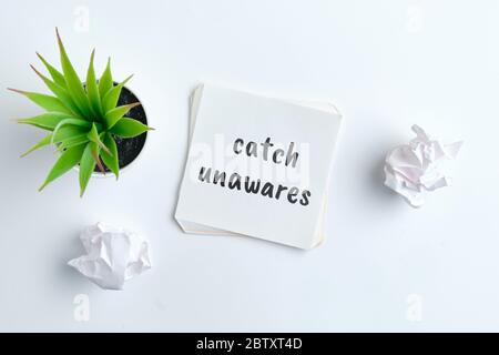 Catch Unawares - englische Zeitsprache Handschriftzug auf Holzblöcken. Stockfoto