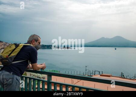 In Neapel - Italien - am 05/ 23/ 2020 - Mann mit einer Sicherheitsmaske und Blick auf die Landschaft des Neapelischen Golfs Stockfoto