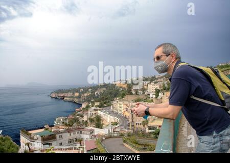 In Neapel - Italien - am 05/ 23/ 2020 - Mann mit einer Sicherheitsmaske und Blick auf die Landschaft des Neapelischen Golfs Stockfoto