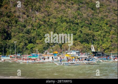 Morgen Szene am El Nido Beach, El Nido, Palawan, Philippinen, während die Tagesboote vorbereiten, um Touristen zu den Inseln und Stränden zu bringen. Stockfoto