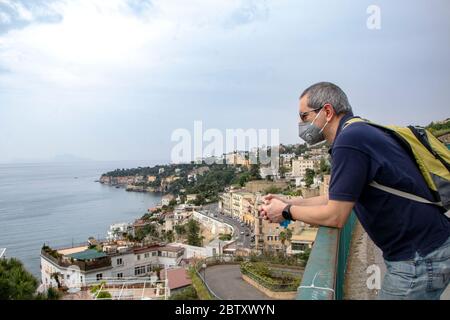 In Neapel - Italien - am 05/ 23/ 2020 - Mann mit einer Sicherheitsmaske und Blick auf die Landschaft des Neapelischen Golfs Stockfoto