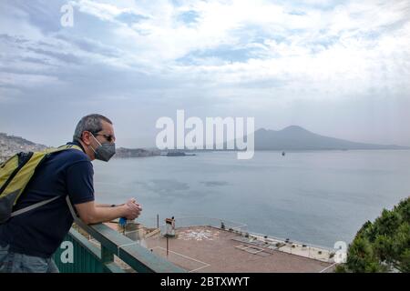 In Neapel - Italien - am 05/ 23/ 2020 - Mann mit einer Sicherheitsmaske und Blick auf die Landschaft des Neapelischen Golfs Stockfoto