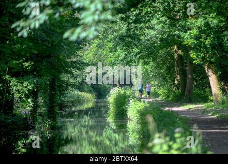 Swansea, Wales, Großbritannien. 28. Mai 2020.zwei Menschen genießen einen Spaziergang in der Sonne über den Swansea Canal in Pontawe, Südwales an einem anderen herrlichen Tag in Großbritannien, während das gute Wetter anhält und der Sommer während der Sperrzeit stattfindet. Quelle : Robert Melen/Alamy Live News. Stockfoto