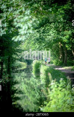 Swansea, Wales, Großbritannien. 28. Mai 2020.zwei Menschen genießen einen Spaziergang in der Sonne über den Swansea Canal in Pontawe, Südwales an einem anderen herrlichen Tag in Großbritannien, während das gute Wetter anhält und der Sommer während der Sperrzeit stattfindet. Quelle : Robert Melen/Alamy Live News. Stockfoto