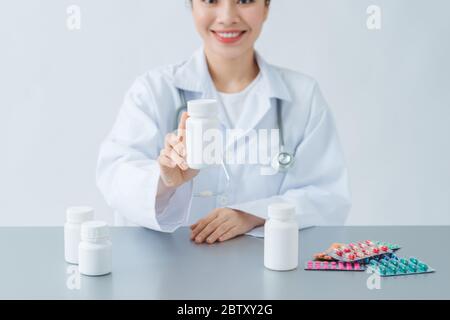 Schöne Ärztin Medizin Arzt oder Apotheker sitzt am Arbeitstisch Stockfoto