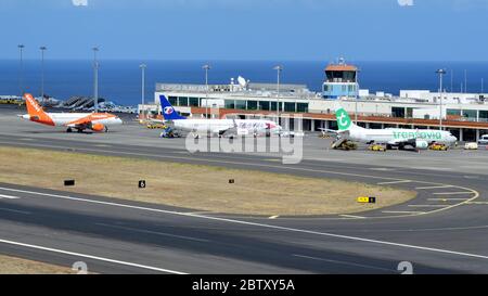 Ein Foto mit der Sicht auf den Flughafen Funchal, komplett mit drei Flugzeugen verschiedener Billigfluggesellschaften Stockfoto