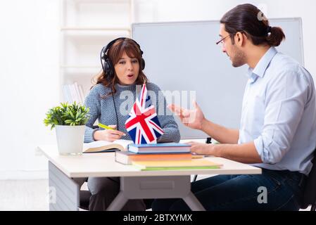 Junger Schüler und männlicher englischlehrer im Klassenzimmer Stockfoto