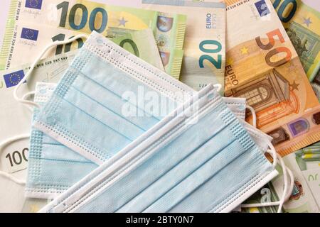 Masken werden auf Euro-Banknoten Geschäftsgeld gelegt Stockfoto