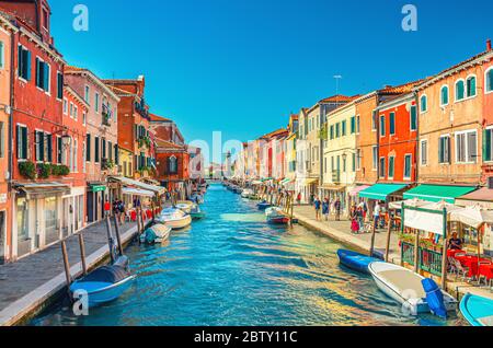 Murano, Italien, 14. September 2019: Insel, Brücke über den Wasserkanal, Boote, Motorboote, bunte traditionelle Gebäude, Lagune von Venedig, Region Venetien, San Michele in Isola katholische Kirche Stockfoto