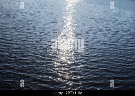 Die Sonnenstrahlen auf dem ruhigen Fluss Stockfoto