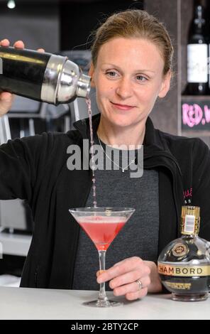 Ein Barkeeper in Coventry, England, gießt einen klassischen rosafarbenen Cocktail Stockfoto