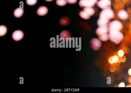 Glänzendes Bokeh auf schwarzem Hintergrund. Abstrakt unfokussierten Urlaub Hintergrund. Stockfoto