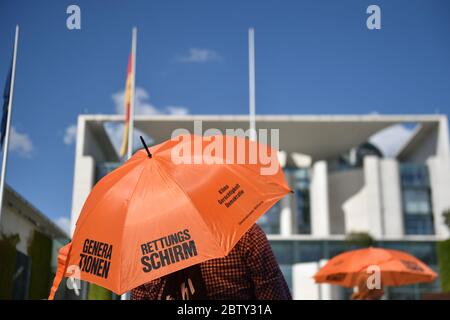 Berlin, Deutschland. Mai 2020. Demonstranten halten Schirme vor dem Kanzleramt zu Beginn der Kampagne "Generationenschirm" der Stiftung Generationen. Eines der Ziele der Kampagne ist es, die wirtschaftliche Hilfe Corona an soziale und ökologische Bedingungen zu binden. Quelle: Sven Braun/dpa/Alamy Live News Stockfoto