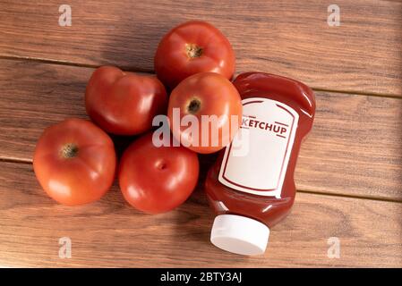 Ketchup-Sauce mit vielen Tomaten auf braunem Holzbrett Stockfoto