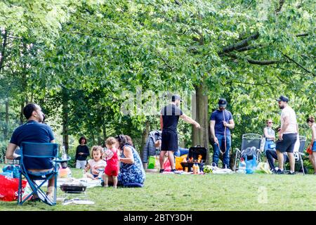 Leute picknicken im Waterlow Park, North London, unter Missachtung der vielen prominenten Schilder, die Grillabende verbieten und Regierungsratschläge zu sozialer und physischer Distanzierung geben Stockfoto