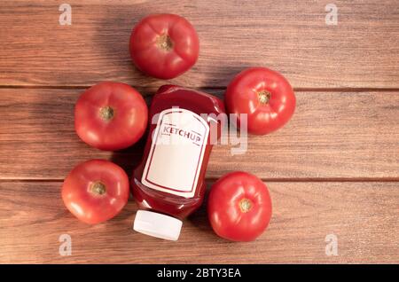 Ketchup-Sauce mit vielen Tomaten auf braunem Holzbrett Stockfoto