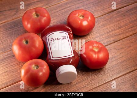 Ketchup-Sauce mit vielen Tomaten auf braunem Holzbrett Stockfoto