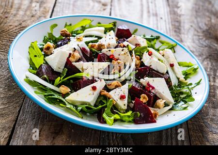 Salat mit Rüben, Feta-Käse und Walnüssen auf Holzgrund Stockfoto