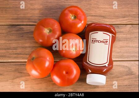 Ketchup-Sauce mit vielen Tomaten auf braunem Holzbrett Stockfoto