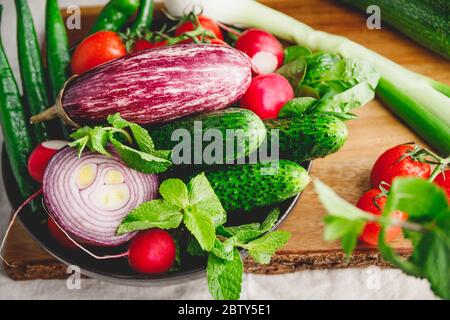 Verschiedene frische lebendige Gemüse in einem Teller auf einem Holztablett Stockfoto
