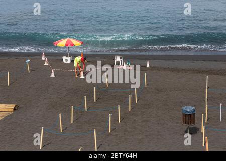 Playa de La Arena, Santiago del Teide, Teneriffa, Kanarische Inseln, Spanien. Mai 2020. Die Arbeiter bereiten den Strand mit abgesperrten Bereichen vor, um die soziale Distanz, zwei Meter voneinander entfernt, und den kontrollierten Zugang für die Öffentlichkeit während der zweiten Phase der Deeskalation des Covid 19, Coronavirus Notstand, der voraussichtlich bis zum 7. Juni dauern wird. Stockfoto