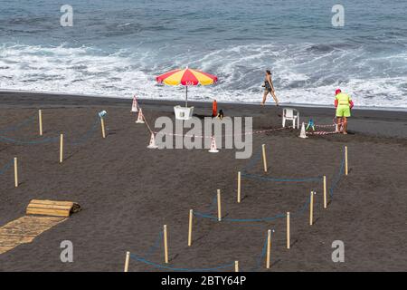 Playa de La Arena, Santiago del Teide, Teneriffa, Kanarische Inseln, Spanien. Mai 2020. Die Arbeiter bereiten den Strand mit abgesperrten Bereichen vor, um die soziale Distanz, zwei Meter voneinander entfernt, und den kontrollierten Zugang für die Öffentlichkeit während der zweiten Phase der Deeskalation des Covid 19, Coronavirus Notstand, der voraussichtlich bis zum 7. Juni dauern wird. Stockfoto